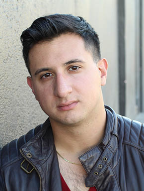 Portrait of a handsome young man with neutral expression at camera, isolated on gray