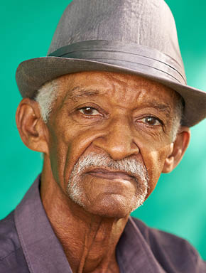 Real Cuban people and feelings, portrait of sad senior hispanic man looking at camera. Worried old latino grandfather with mustache and hat from Havana, Cuba